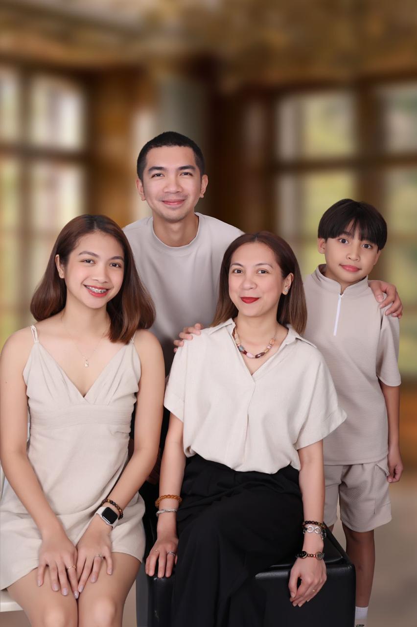 Family of four in neutral tones photographed in a warm sunlit setting