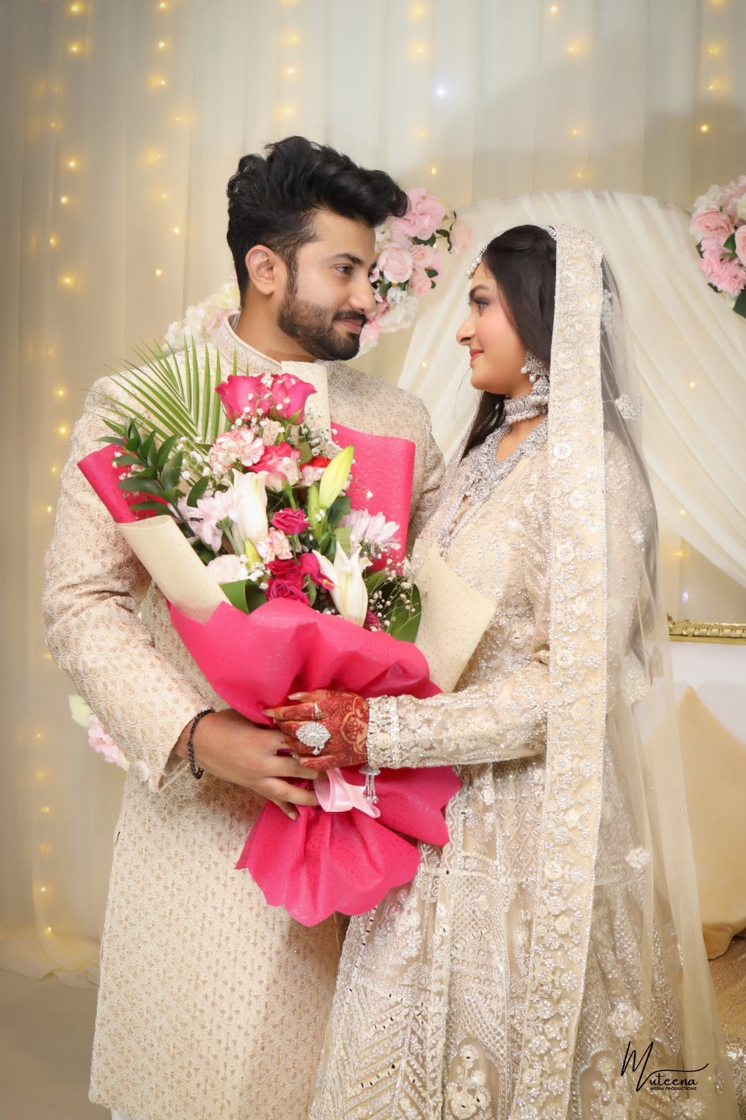 Muslim bride and groom during a Dubai nikkah ceremony holding a pink rose bouquet — wedding photography by Dar Al Muteena Studio