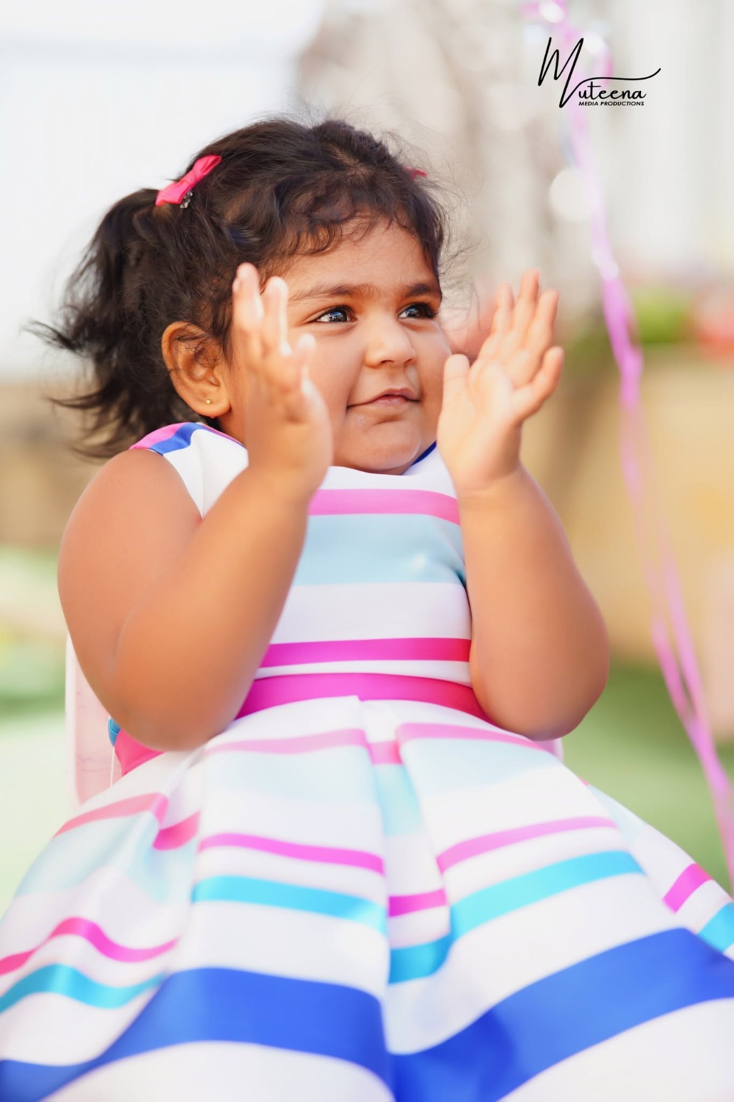 Little girl in a navy blue sequinned kurta lifting a gold number four foil balloon above her head in a golden wheat field — 4th birthday photography Dubai